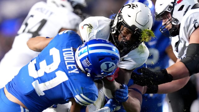 Cincinnati Bearcats running back Corey Kiner (21) is tackled by Brigham Young Cougars linebacker Max Tooley (31) in the third quarter during a college football game between the Brigham Young Cougars and the Cincinnati Bearcats, Saturday, Sept. 30, 2023, at LaVell Edwards Stadium in Provo, Utah.